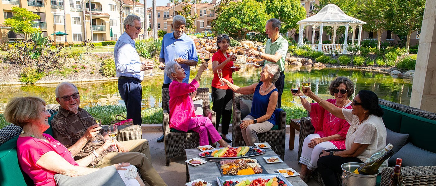 A group of residents chatting and drinking cocktails outdoors